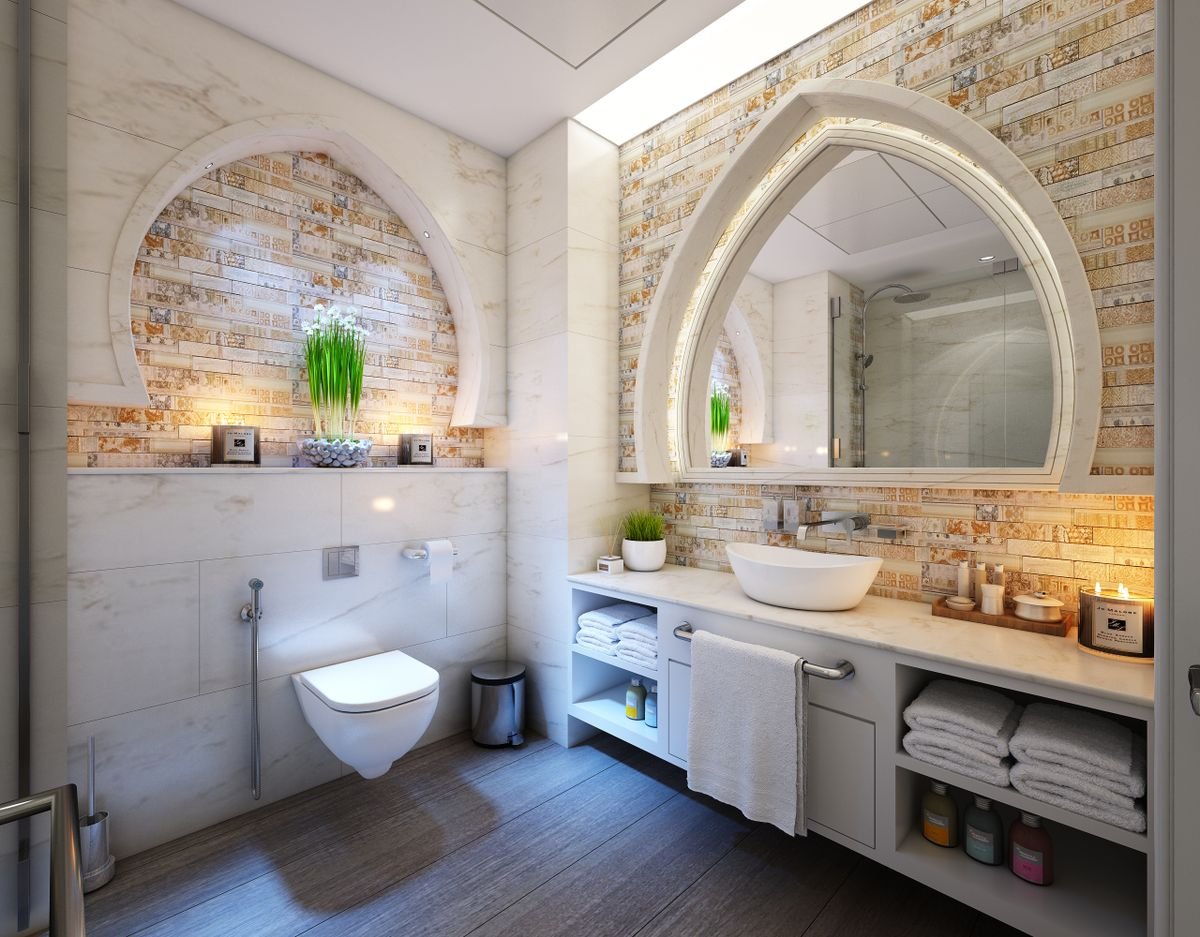 Natural stone clad bathroom with arched mirrors